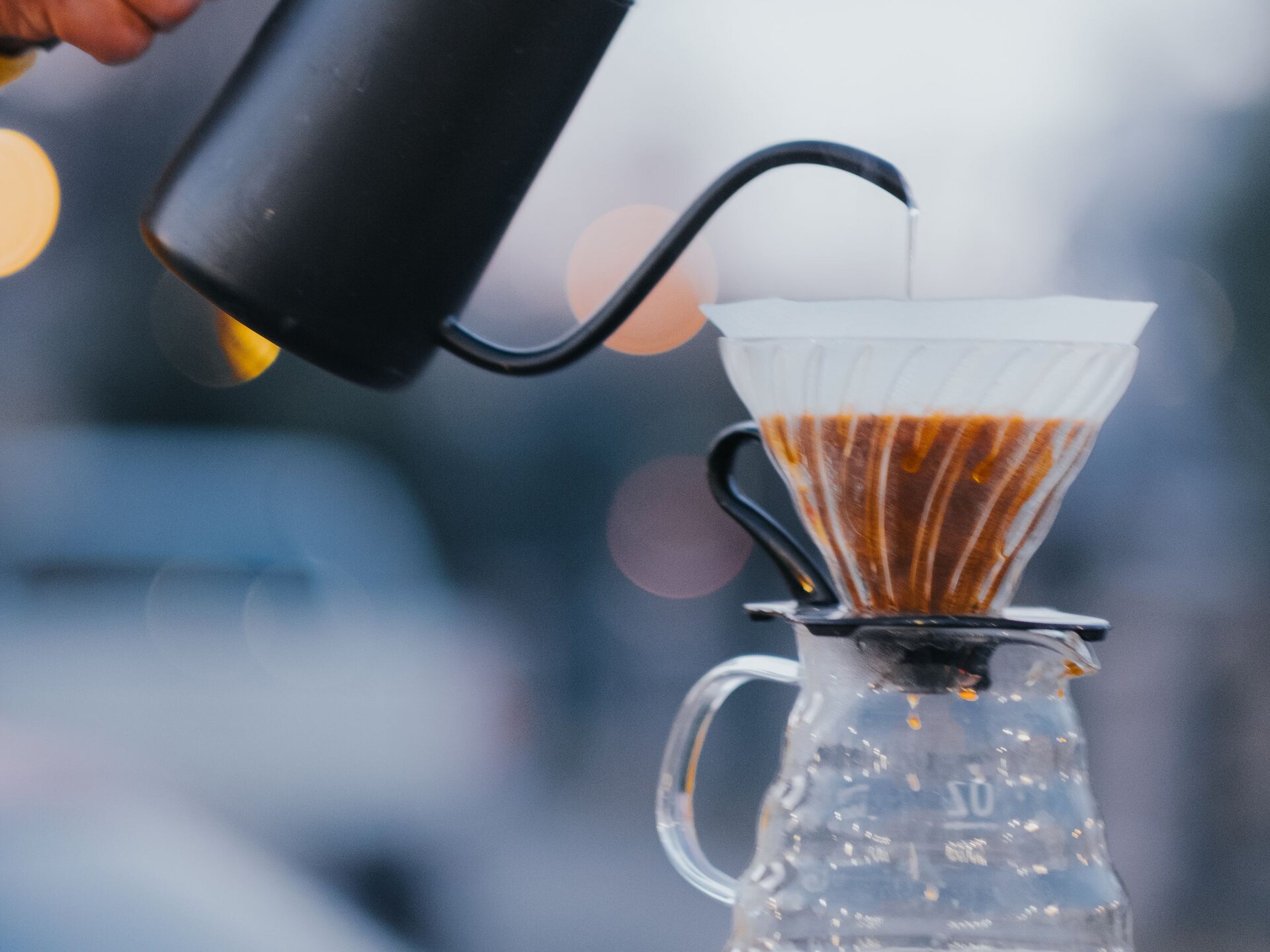 Eau chaude versée à la bouilloire dans un dripper V60 pendant la préparation d'un café filtre