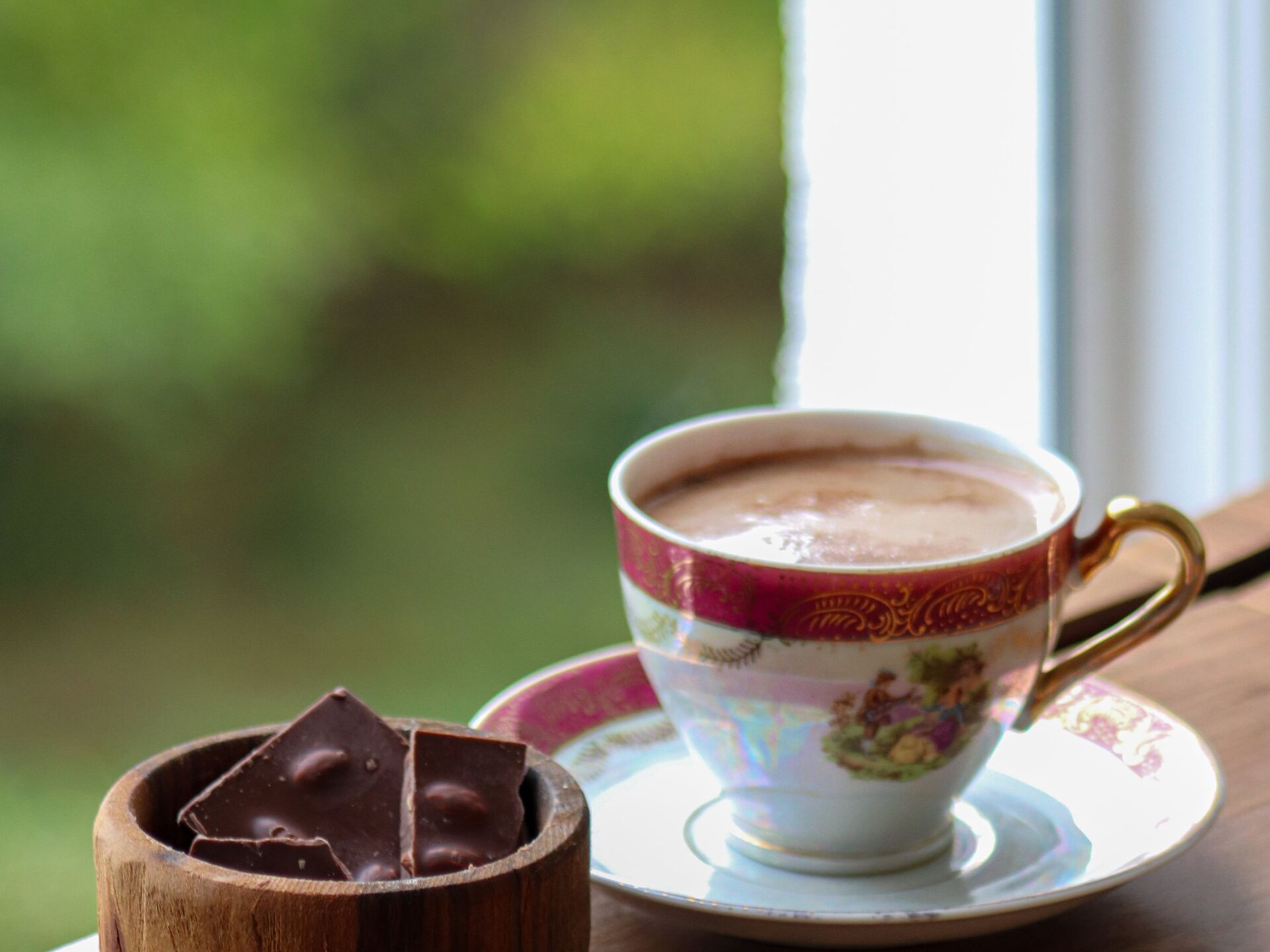 Tasse de chocolat chaud et morceaux de chocolat sur une table en bois