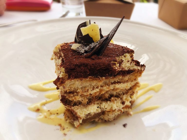 Part de tiramisu saupoudrée de cacao, dans une assiette